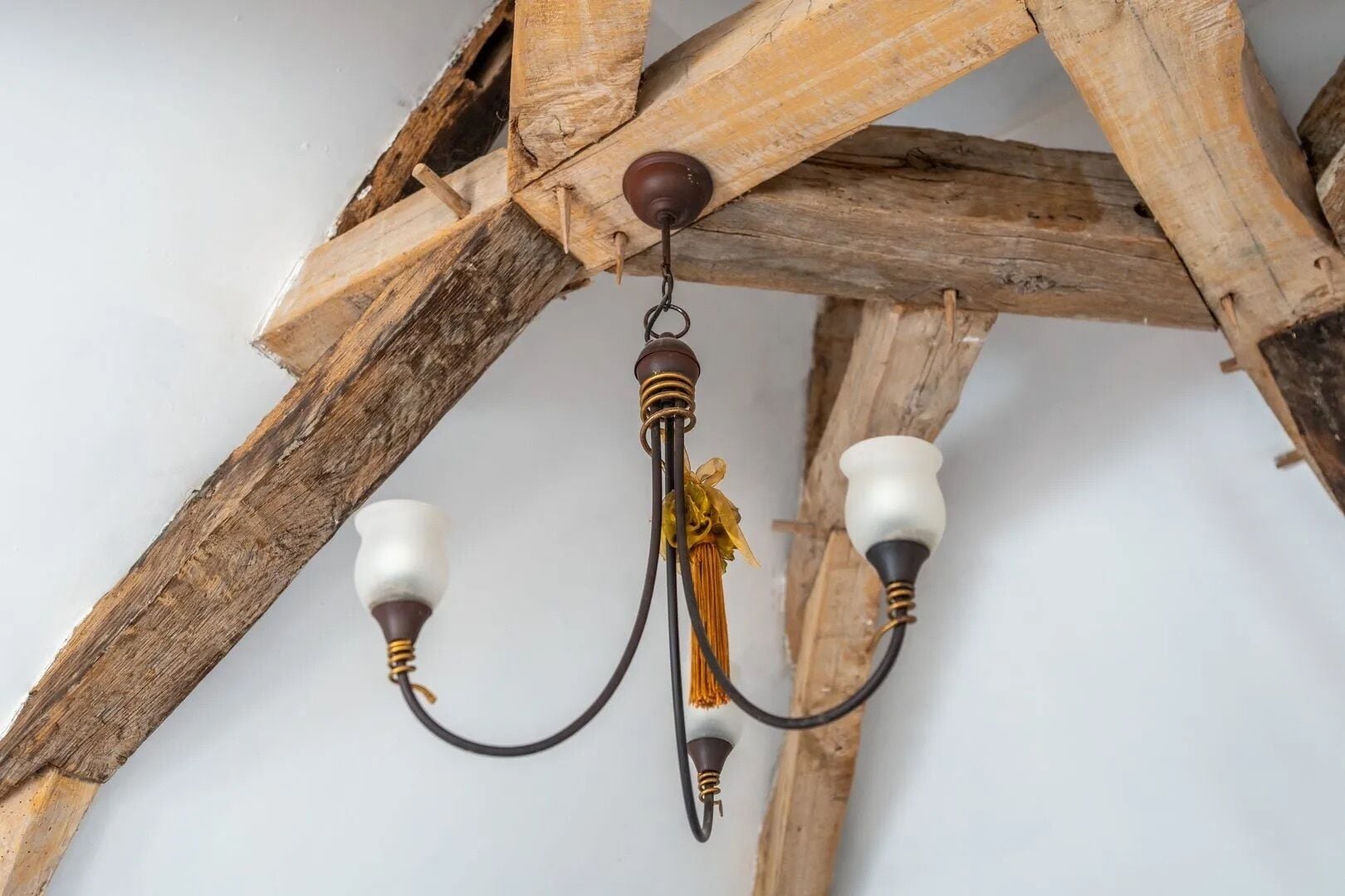 Un candelabro con estructura de madera y dos pantallas blancas.