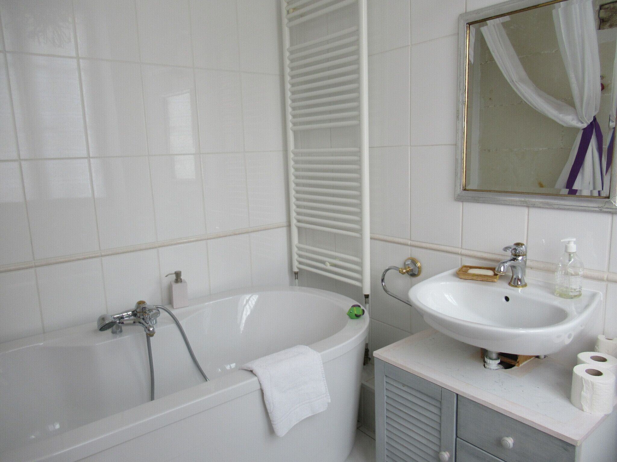 Un baño con bañera, lavabo y espejo.