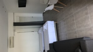 A modern hotel room with a bed, a sofa, a desk, and a chair. - KalliGeoM (Hersonissos)