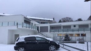 A modern building with a car parked in front. - Euro Apartment (Interlaken)