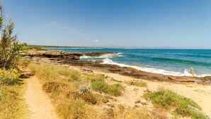 A coastal path leading to rocky shores with clear blue waters and distant mountains. - EMBAT - Seafront house with garden, pool and bbq. (Colonia San Pedro)