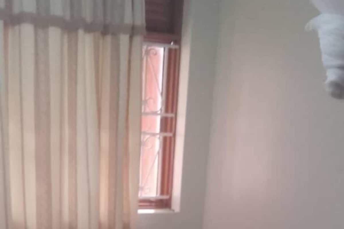 Una habitación con cama, ventana y cortinas.
