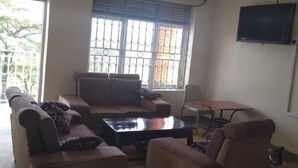 Un salon comprenant un canapé, une table basse et un téléviseur fixé au mur.