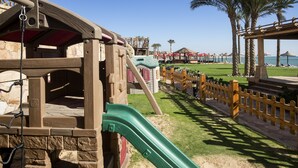 A playground with a slide, wooden play structures, and a sandy area. - Cancun Sokhna Resort & Villas (Ataqah)