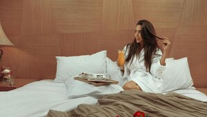 A hotel room with a bed, pillows, a tray with breakfast items, and a glass of orange juice. - Cancun Sokhna Resort & Villas (Ataqah)