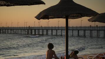 On the beach, beach umbrellas, beach towels, beach volleyball