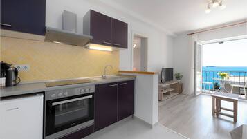 Apartamento, vista para o mar | Cozinha americana privada | Geladeira, cafeteira/chaleira, talheres/pratos/utensílios de cozinha