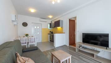 Apartment, Meerblick | Wohnbereich | 100-cm-Flachbildfernseher mit Digitalempfang