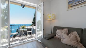 Apartamento, vista para o mar | Área de estar | TV de tela plana 100 cm com canais digitais