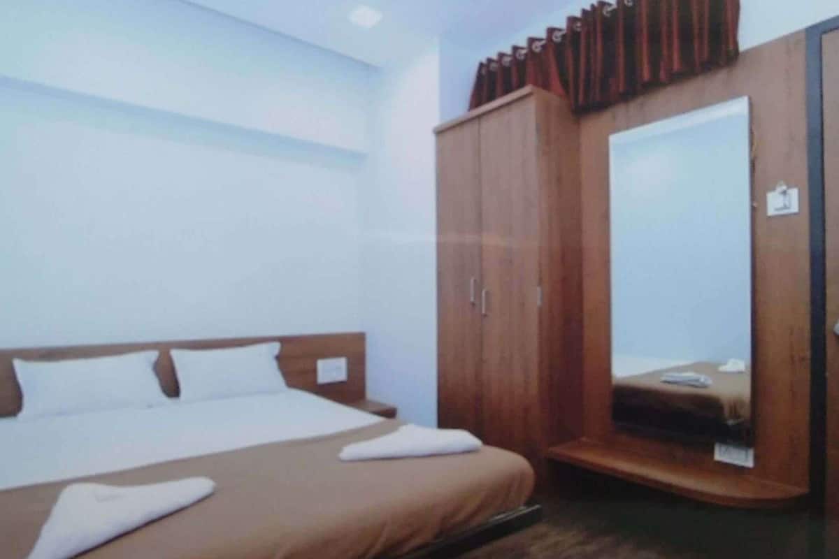 Ein Schlafzimmer mit Bett, Kleiderschrank und Spiegel.