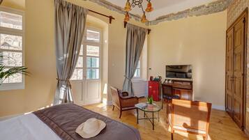 Un dormitorio con cama, escritorio, silla y televisor.