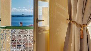 A room with a view of the sea, a balcony with a metal railing, and a curtain tied with a rope. - Palazzo Santa Maria - Historic Hotels of Europe (Syros)