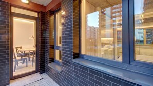 A modern building exterior with large windows, a brick facade, and a visible dining area with chairs and a table. - Kauno-Algirdo Luxury Vilnius Apartments (Vilnius)