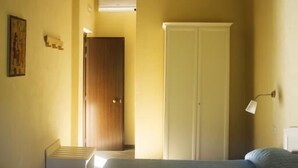 A bedroom with a bed, a wardrobe, and a desk.