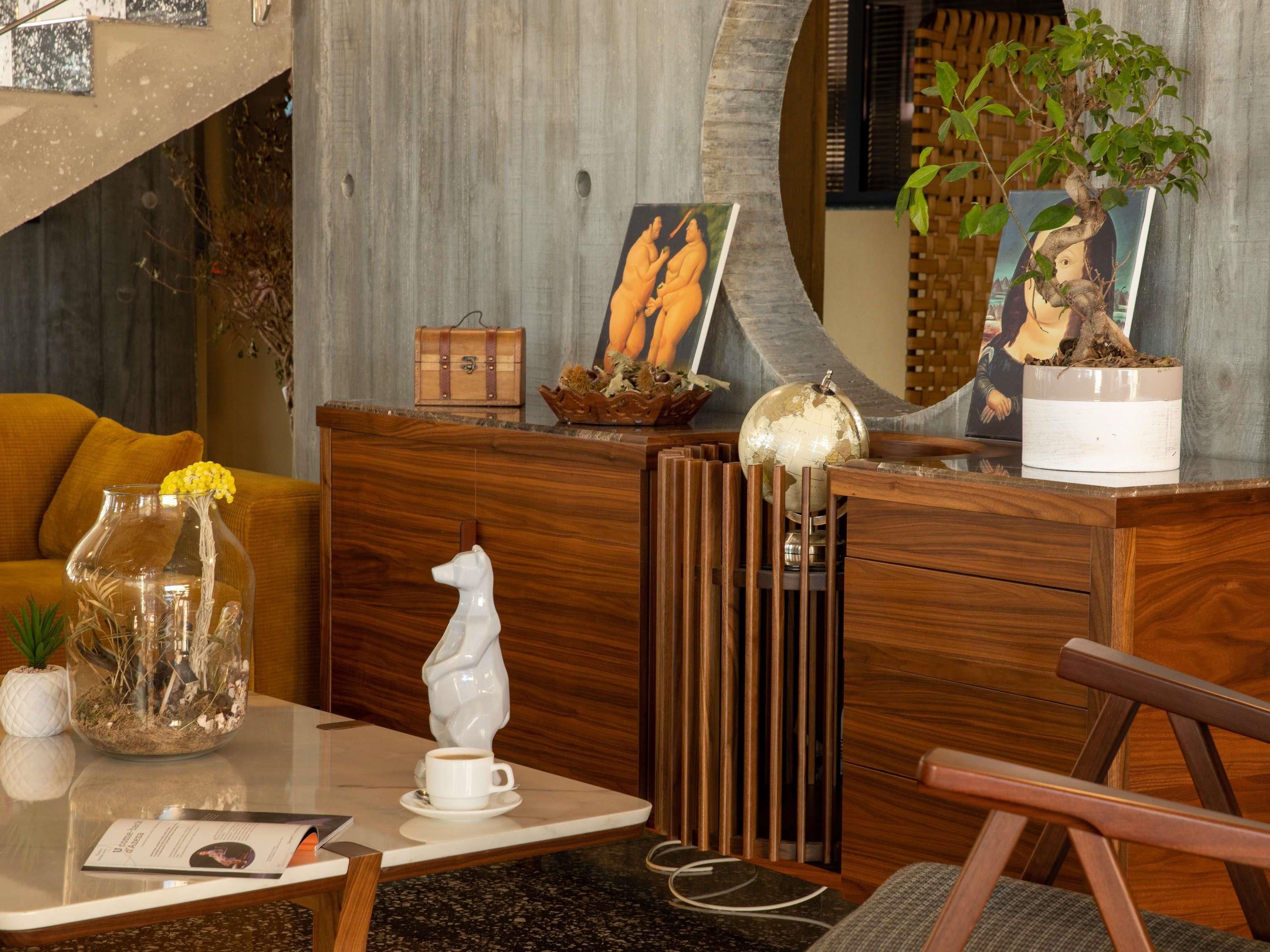 A wooden reception desk with a globe, a white horse sculpture, and a plant.