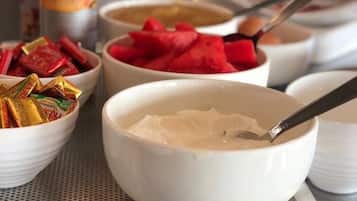 A kitchen counter with various food items and containers, including bowls of food and condiments.