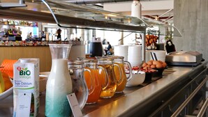 Ett område med en buffé där det finns ett urval av drycker, inklusive en förpackning Bio Village-sojadryck berikad med kalcium, en kanna mjölk och flera muggar te.