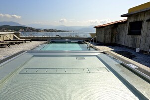 Una piscina en la azotea con vistas al mar y a las montañas.