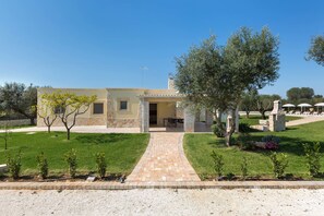 A two-story house with a paved driveway leading to a covered outdoor seating area. - Trulli di Buontempo (Francavilla Fontana)