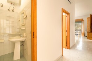 A bathroom with a sink, mirror, and towel rack.