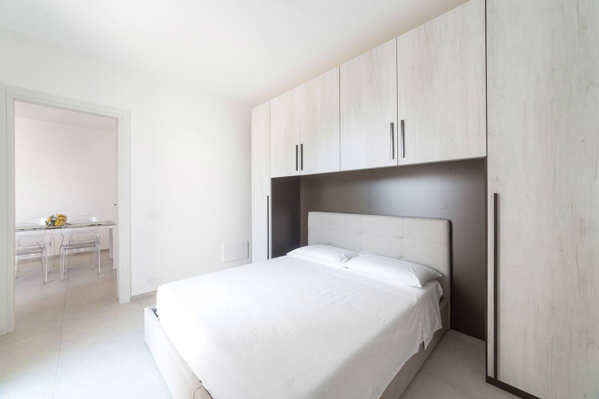 Quarto moderno com uma cama, uma escrivaninha e uma cadeira.