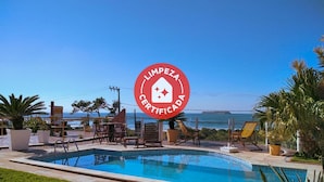 A pool area with lounge chairs and a view of the sea. - Pousada Bangalôs Da Mole - Florianópolis (Florianópolis)