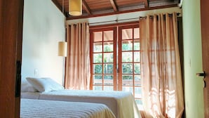 A room with two beds, a window with curtains, and a wooden ceiling. - Pousada Bangalôs Da Mole - Florianópolis (Florianópolis)