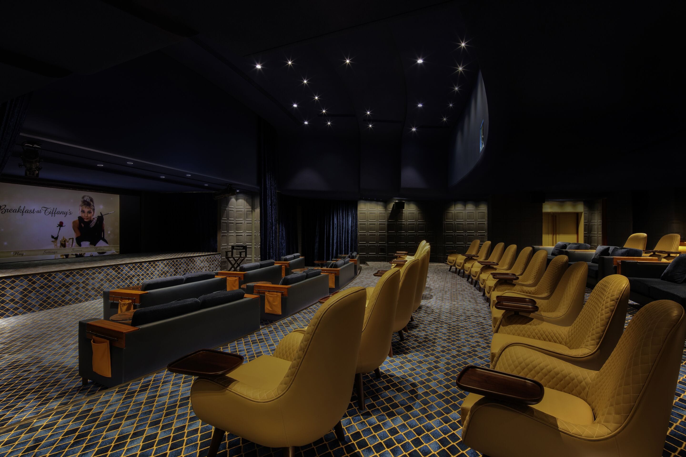 A cinema with rows of seats, a screen, and a projection booth.