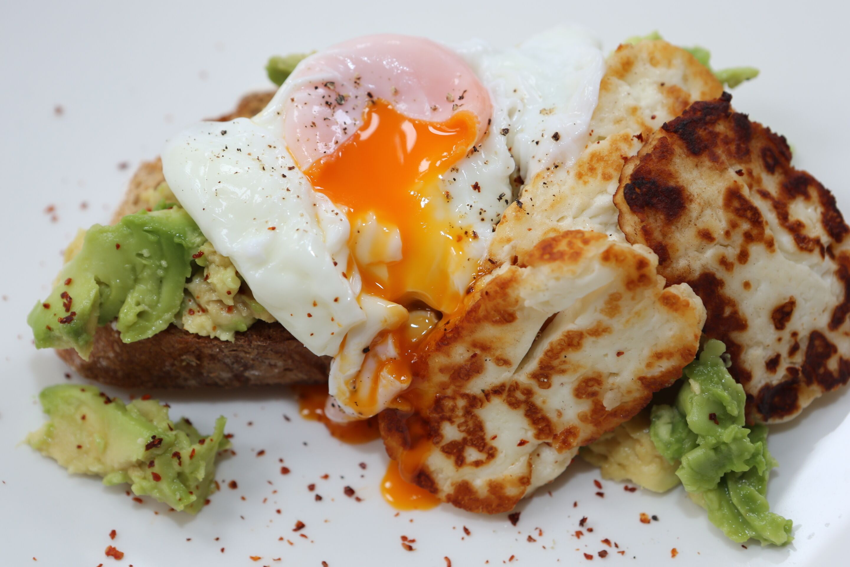 Ein Frühstücksteller mit Spiegelei, Avocado und Toast.