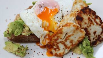 Ein Frühstücksteller mit Spiegelei, Avocado und Toast.