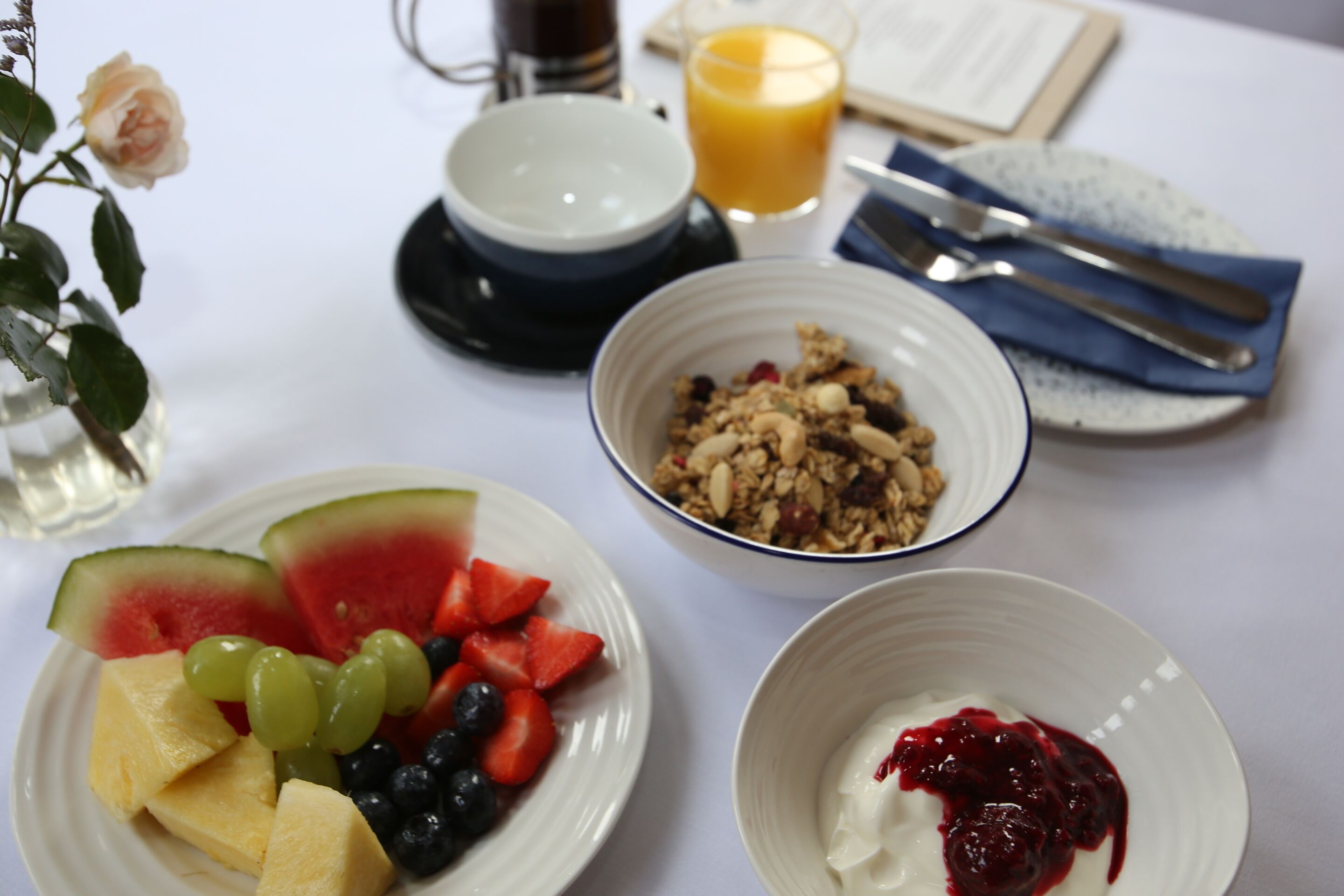 Desayuno con platos de fruta, yogur y granola.