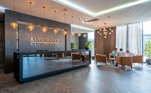 Welcome to King David Residences, where guests can relax in the reception area, surrounded by comfortable seating and a warm atmosphere.
