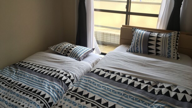 Ein Schlafzimmer mit zwei Betten, jeweils mit gemusterten Bettbezügen und Kissen.