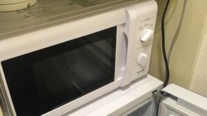 Eine kleine Küche mit Mikrowelle und Backofen.