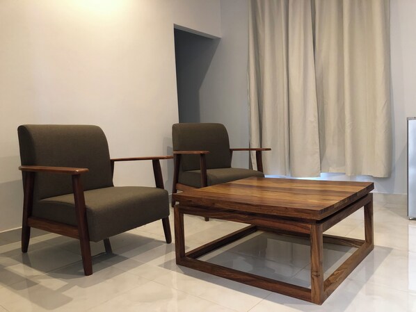 A modern living room with two dark green armchairs and a wooden coffee table with a glass top. - Villa la Vallée (Bakel)