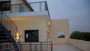 Un bâtiment moderne doté d’un escalier en colimaçon, d’un balcon et d’une porte.