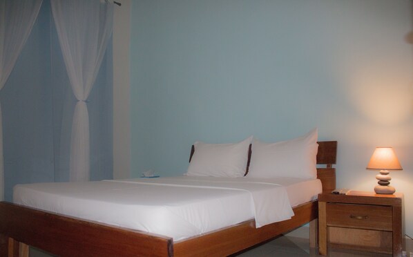 A single bed with white linens in a room with light blue walls. - Villa la Vallée (Bakel)