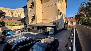 Un edificio de diseño moderno, con una combinación de balcones y una entrada a nivel de calle.