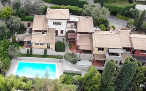 A residential area with multiple houses, a swimming pool, and well-maintained gardens.