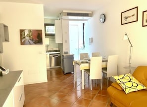 Una cocina moderna con comedor, un sofá y un reloj en la pared.