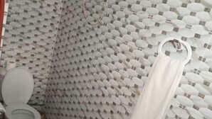 Un baño con un papel tapiz estampado, un inodoro, un lavabo y una toalla colgada en la pared.