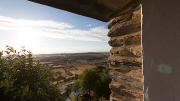 A stone wall with a view of a valley and fields.