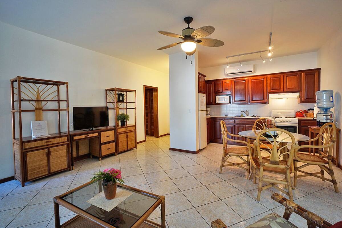 A modern kitchen with wooden cabinets, a microwave, and a water dispenser.