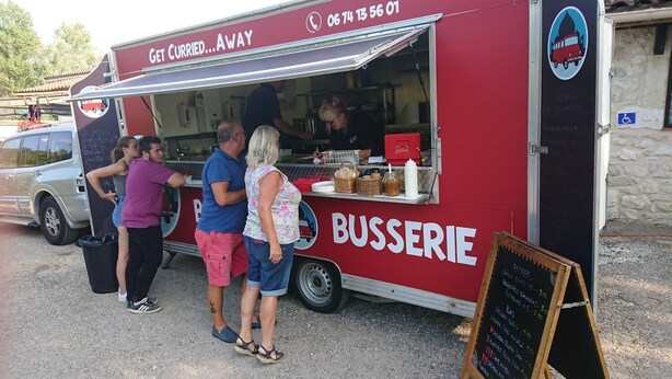 A food truck with a menu board and a sign that reads "Get Cured... Away". - Le Cabri Resort (Duras)