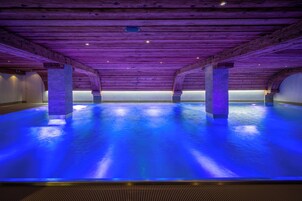 Una piscina techada, sillones reclinables de piscina