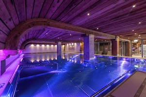 Una piscina techada, sillones reclinables de piscina