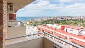 A balcony with a view of a coastal cityscape, including buildings and a body of water. - Cozy apartment with pool and sea views (Benalmádena)