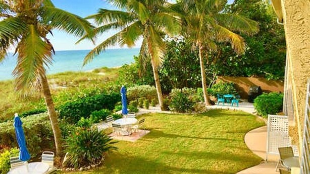 A tropical garden with palm trees, a lawn, and outdoor seating. - Now Open! 7-Night Deal – Oceanfront w/ Private Balcony & Stunning Views (Longboat Key)