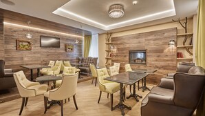 A modern living room with a fireplace, comfortable seating, and a flat-screen TV. - Honour and Grace Hotel (Ostrov)