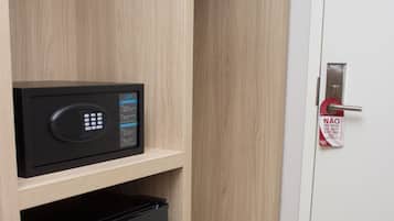 Een kleine keuken met een magnetron en een zwarte koelkast op houten planken.